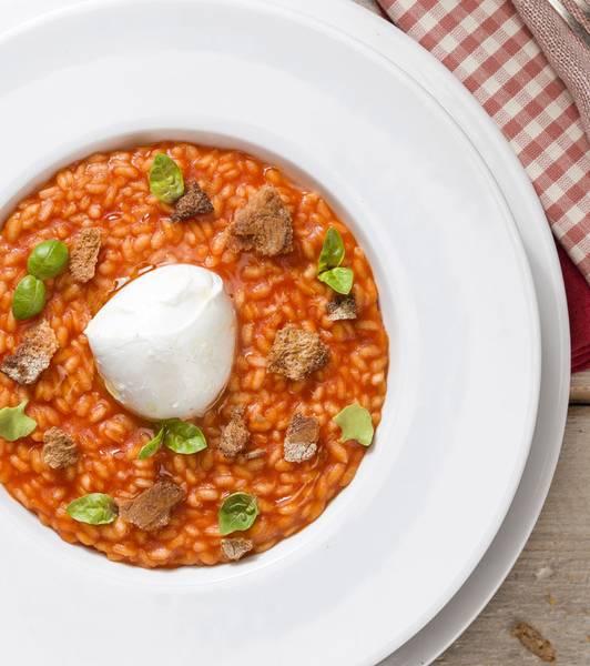 TOMATEN-RISOTTO MIT EINEM HERZEN AUS BÜFFELMOZZARELLA UND MIT RÖSTBROT UND BASILIKUM