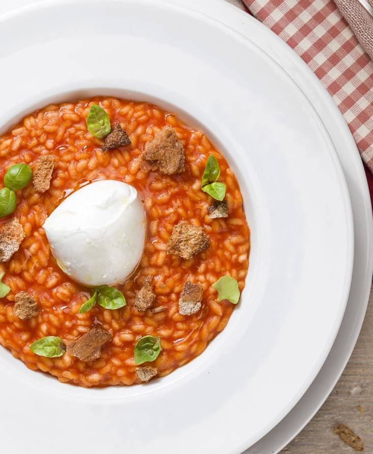 TOMATEN-RISOTTO MIT EINEM HERZEN AUS BÜFFELMOZZARELLA UND MIT RÖSTBROT UND BASILIKUM